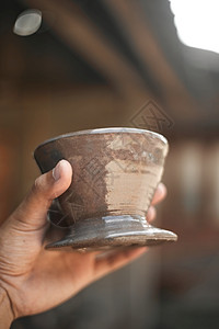 酿造杯子近手握着模糊背景的滴水器陶瓷近手握着滴水器陶瓷咖啡因图片