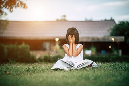 孩子学生女在家庭花园读书的无聊女孩图片