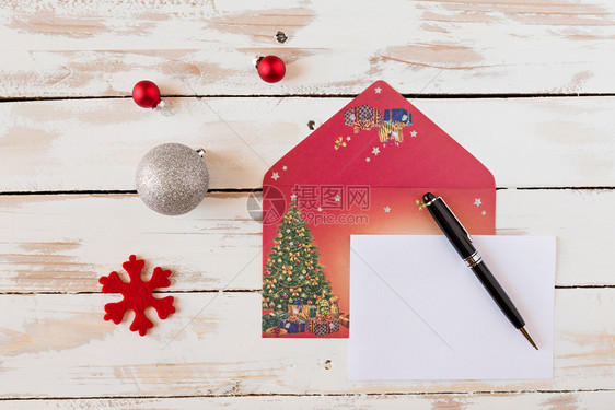 莫比代利圣诞信和笔放在一个生锈的木制桌子上带有装饰品的圣诞信在生锈木制桌子上白色的十二月图片