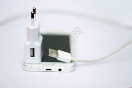 白色的活力现代智能手机和电话充线隔离在白黑地上技术图片