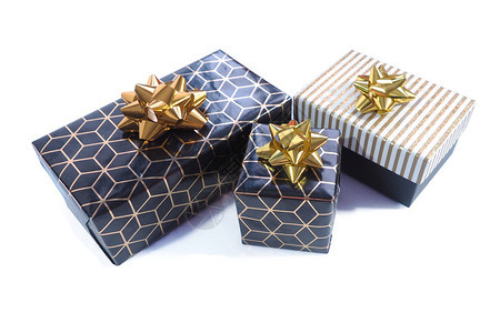 礼物菱形丝带三个礼品盒是黑色的有几何图案金弓和黑色白金光亮的盖子和弓白背景的伊索拉特图片
