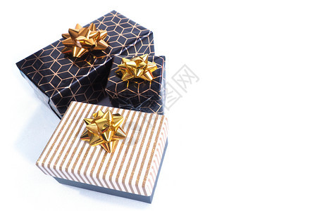 银丝带三个礼品盒是黑色的有几何图案金弓和黑色白金光亮的盖子和弓白背景的伊索拉特菱形图片
