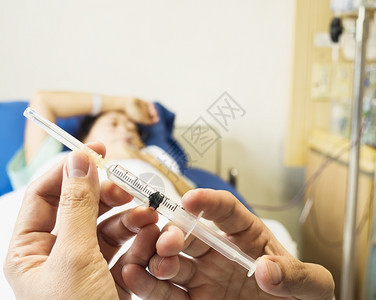 健康医生手持注射器准备在医院内注射有病人背景的注射针头击白色的图片