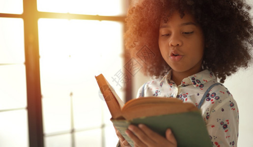 美国人非洲女童在家里读书的教科阅课堂图片