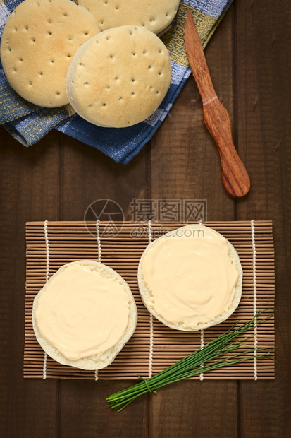 上面的奶油乳酪镜头散布在面包上侧边有一捆子用自然光拍照木制的起司图片