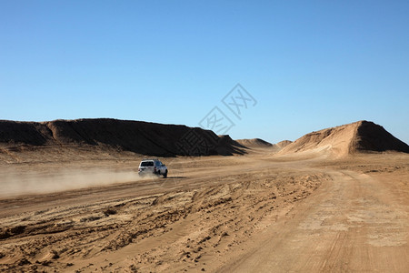孤独旅游沙漠中的汽车路背景图片