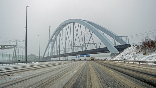 首都在阿姆斯特丹附近的A1高速公路上驾驶在荷兰暴风雪期间在Zandhazen桥的Zandhazen桥城市的交通图片