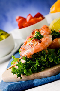 串烧地中海鱼生菜床上美味烤虾的照片蓝底肉桂蛋白尼背景图片