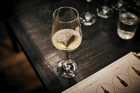 在餐厅的木桌上用玻璃杯和冷白葡萄酒室内的昂贵喝图片