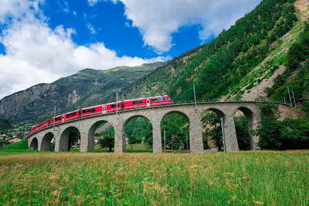 瑞士山火车BerninaExpress穿越环绕的桥以在夏季升空伯尼娜圆圈风景优美背景图片