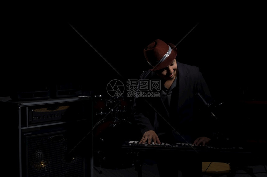 音乐家与黑暗背景的音乐器家概念和一起玩键盘黑暗的色艺术图片