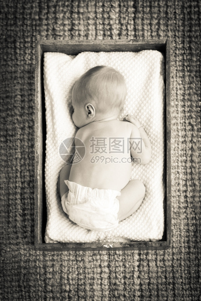 孩子新生婴儿睡在用白布装有的旧木箱内睡眠图片