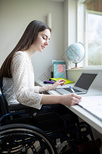 截瘫减值老的在家用笔记本电脑学习的轮椅女青少年图片