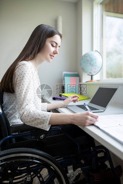 截瘫减值老的在家用笔记本电脑学习的轮椅女青少年图片
