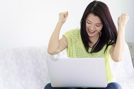 互联网沙发使用笔记本电脑的快乐年轻美女使用笔记本电脑的室内妇女白种人图片