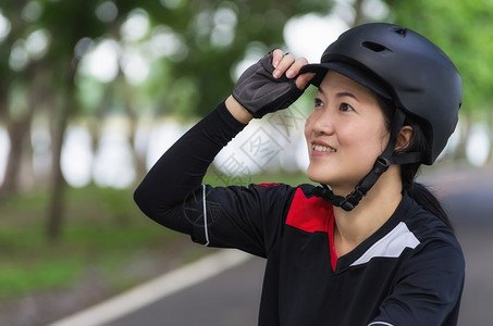 BikeHelmet戴头盔的亚裔妇女编织骑自行车的妇女运动安全孩图片