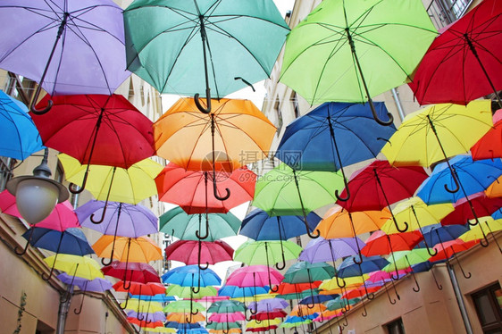 当地的户外蓝色顶部挂彩伞一组不同的雨伞当地标五彩雨伞街道装饰外部彩色设计顶悬挂彩色雨伞图片