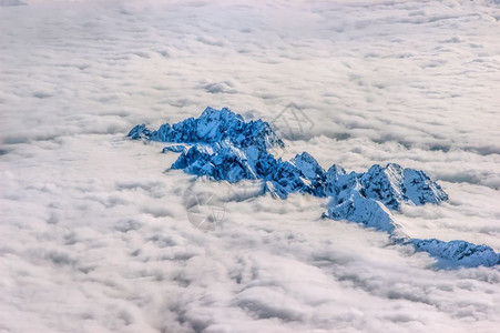 高的阿尔卑斯山覆盖着积雪从云层上看到超过58皮卡图片