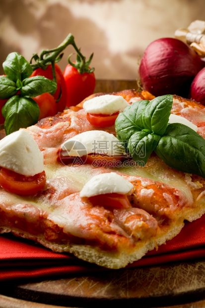 与水牛马扎里拉和木桌上樱桃番茄的美味比萨饼片的食烘烤图片