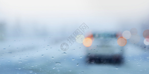 下雨的一天车窗上有雨滴交通灯明亮夜晚路液体图片