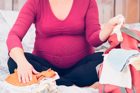 孕妇在准备分娩的医院包中打正面劳动为了图片