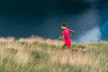 女子运动员在湖上山地草原列火车毅力身体的运动图片