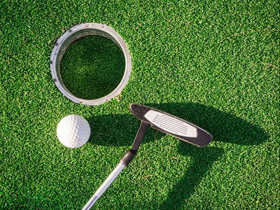 一个高尔夫俱乐部和一个球在迷你高尔夫比赛中球乐趣地毯图片