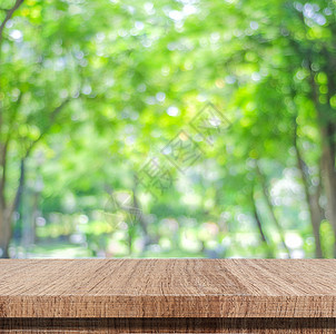 夏天含bokeh背景的模糊树上空木板桌用于产品显示齐装自然叶子图片