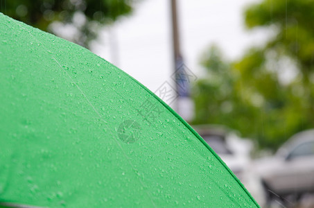 绿色雨伞上的滴水保护丰富多彩的气候图片