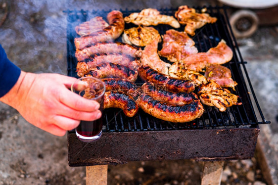 在花园烧烤肉上香肠和猪排热晚餐火焰图片