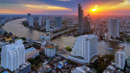 城市景观曼谷日落时靠近河流的现代风景建筑对河附近鸟群的现代建筑进行观察鸟类交通图片