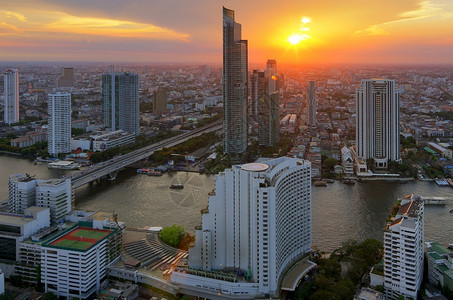 曼谷日落时靠近河流的现代风景建筑对河附近鸟群的现代建筑进行观察酒店地标城市景观图片