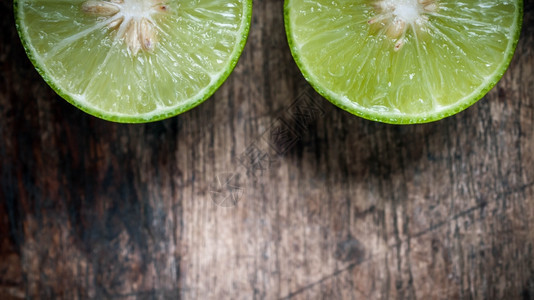 种子健康木制背景的绿色柠檬切割成熟图片