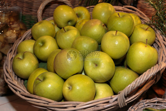 蔬菜营养一顿饭供市场销售的Wicker箱中的绿色苹果堆积图片