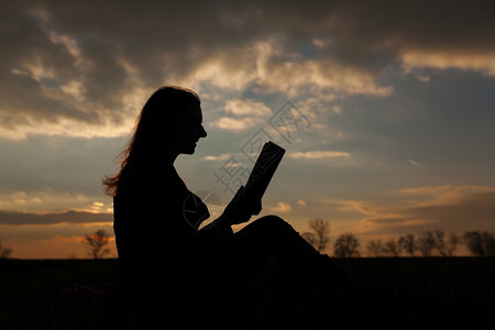 日落时在户外看书的少女微笑学生晚上图片