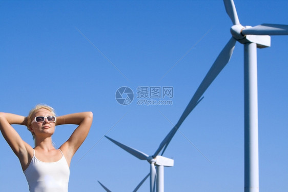 女士白色的年轻子梦想着未来在叶左发电机下的风力农场上纯度图片