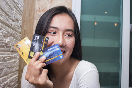 快乐的Asiia妇女展示塑料信用卡在咖啡馆商业概念保持咖啡店银行业图片