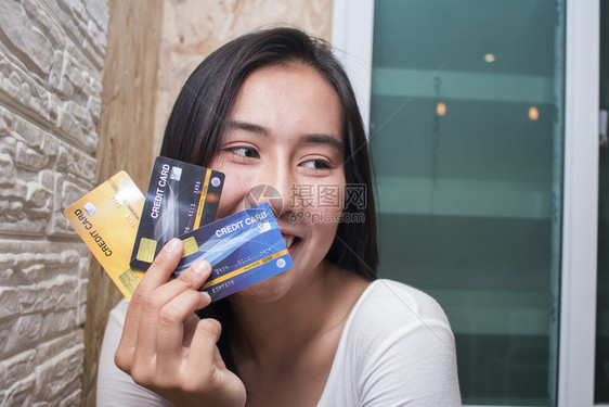 快乐的Asiia妇女展示塑料信用卡在咖啡馆商业概念保持咖啡店银行业图片