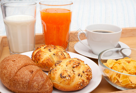 Bed早餐关闭CornFlakes咖啡Croissant橙汁牛奶和床垫胶卷食物卧室枕头图片