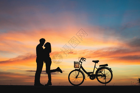 太阳蜜月情人爱侣的休眠在日落时亲吻爱情概念中的夫妻图片