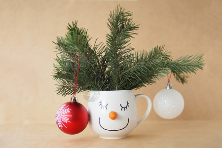 空的圣诞卡杯上面有雪人脸的彩上印有fir树枝和手工艺背景上的圣诞装饰品口假期图片