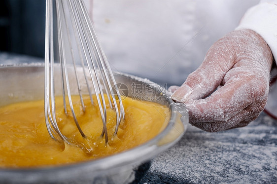 混合厨房一种在松饼碗里移动一个手搅拌机的面包圈图片