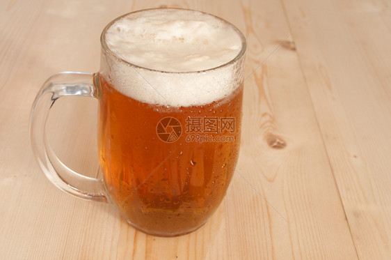 金子木制的桌上满杯啤酒露图片