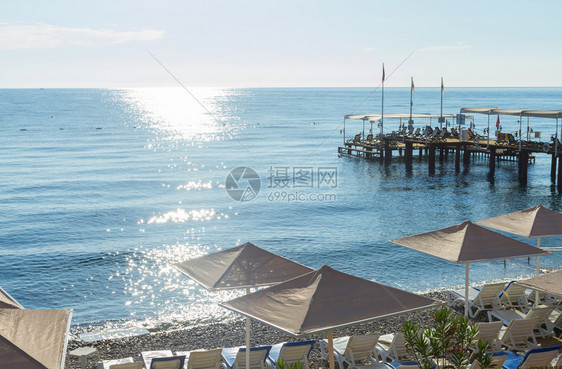 卵石日出自然在土耳其凯默地中海的迈尔滩带有遮阳床的海滨雨伞滩图片