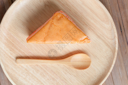 用木勺子把橙蛋糕放在桌上的木板甜点美食早餐图片
