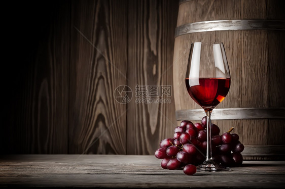 优雅玻璃软木一杯红酒配葡萄和桶在木墙的背景一杯红酒配葡萄和桶图片