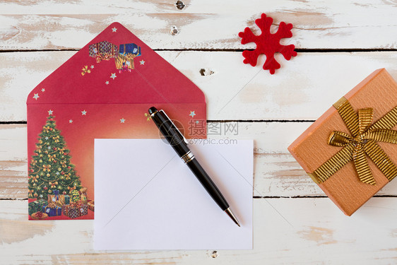 问候空白的圣诞信和笔放在一个生锈的木制桌子上面写着圣诞信上面写着一本生锈的木制桌子上十二月图片