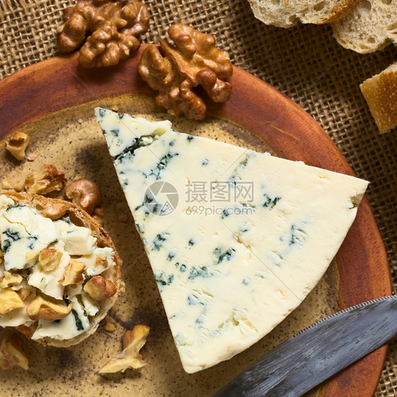 传播起司蓝奶酪和及盘上胡桃甘蔗用自然光选择焦点关注甘蓝顶部和芝士切片拍摄在平面上闻图片