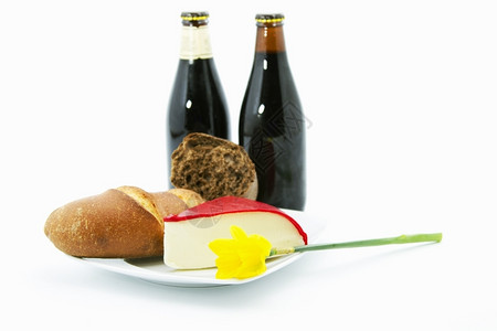 有机的春天两瓶黑啤酒装满一整片面包红干酪在白色的盘子上在真正的乡村午餐里用一只黄色的羊水仙子照亮了小吃图片