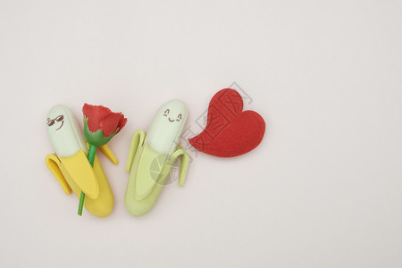 按钮粉红色背景的两个橡胶香蕉和心形枕头情人节概念有趣的创造力图片